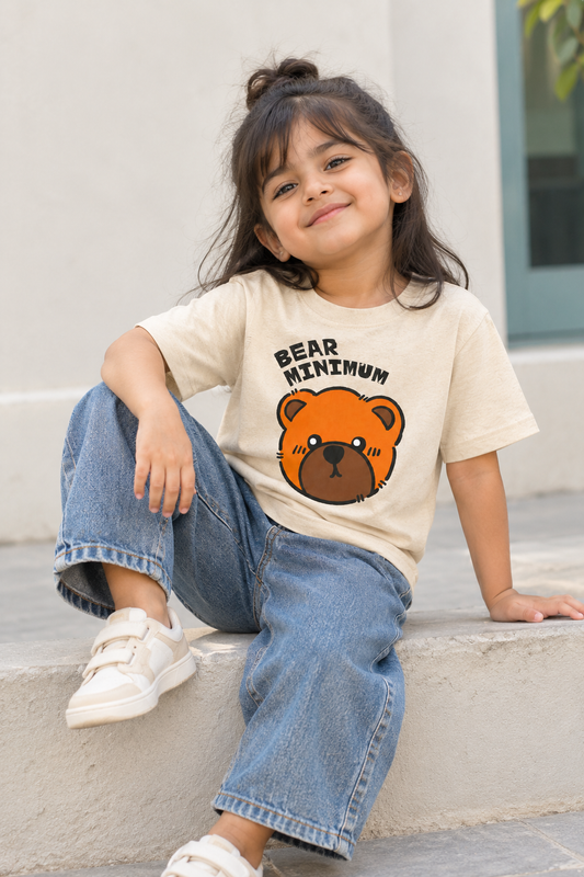Child wearing a beige bear graphic T-shirt